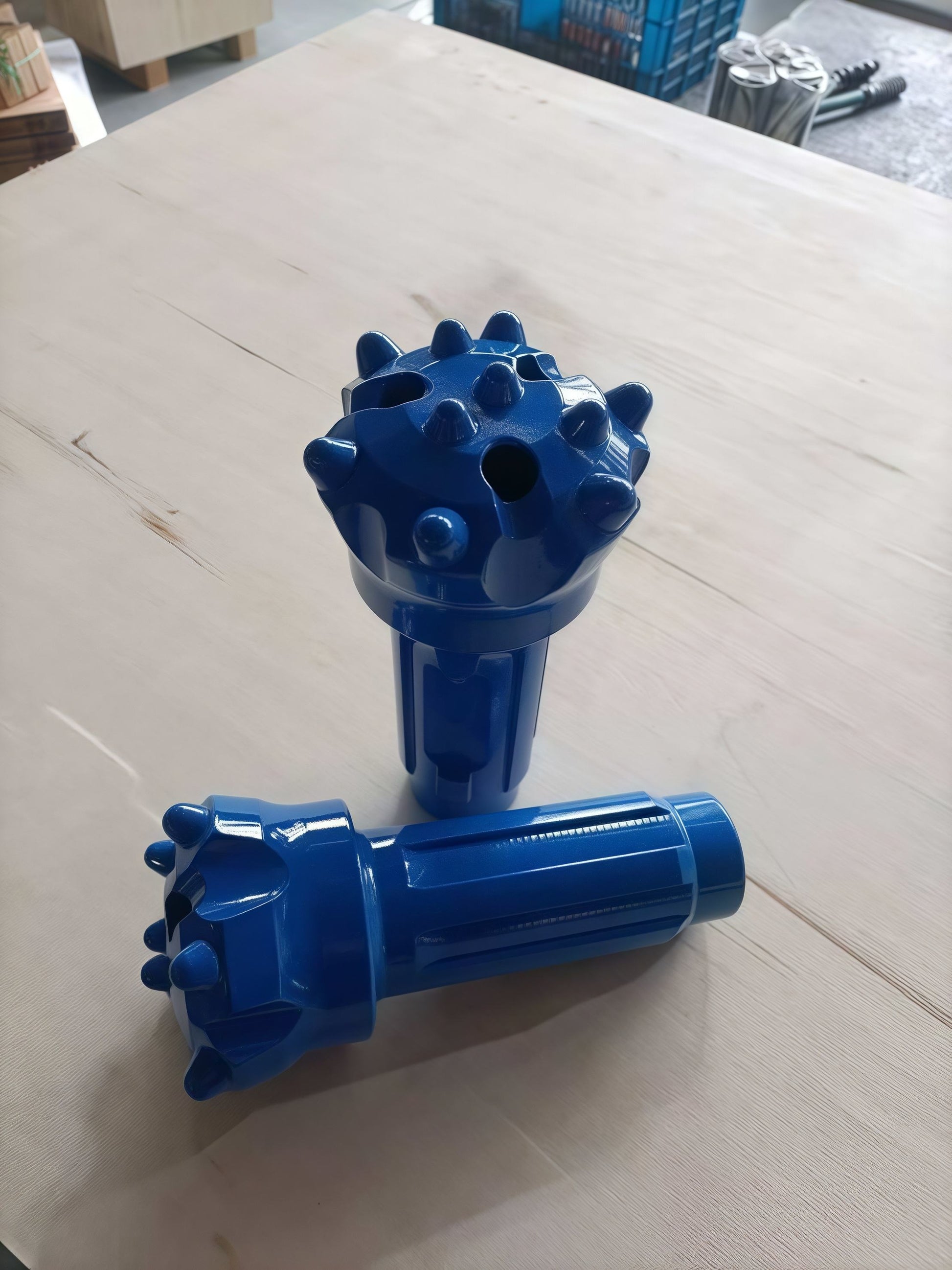 Two blue mining rock drill bits showcased as one upright and one horizontal, ideal for mineral exploration and rock excavation tasks.